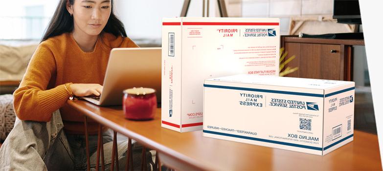Woman on a laptop preparing to send a Priority Mail Express International® box and a Priority Mail International® box.